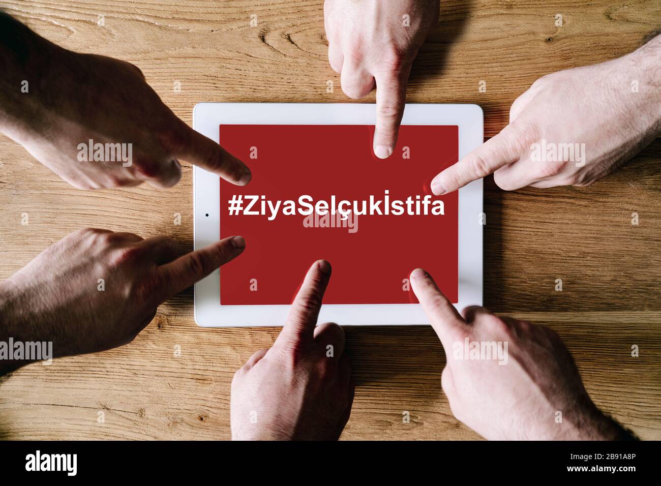 Group Hands zeigen den Bildschirm eines digitalen Tablets mit dem Text des hastag ZiyaSelçukİstifa Ministers für Nationale Bildung Türkisch Stockfoto