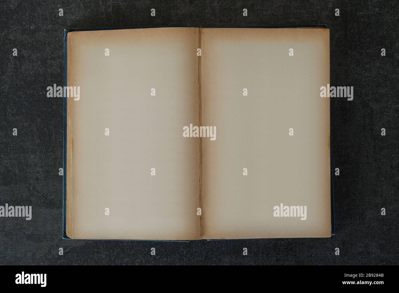 Altes Hardcover-Buch mit leeren Seiten. Altes gelbes Hintergrund-Designelement zum Platzieren von Bildern und Text. Stockfoto