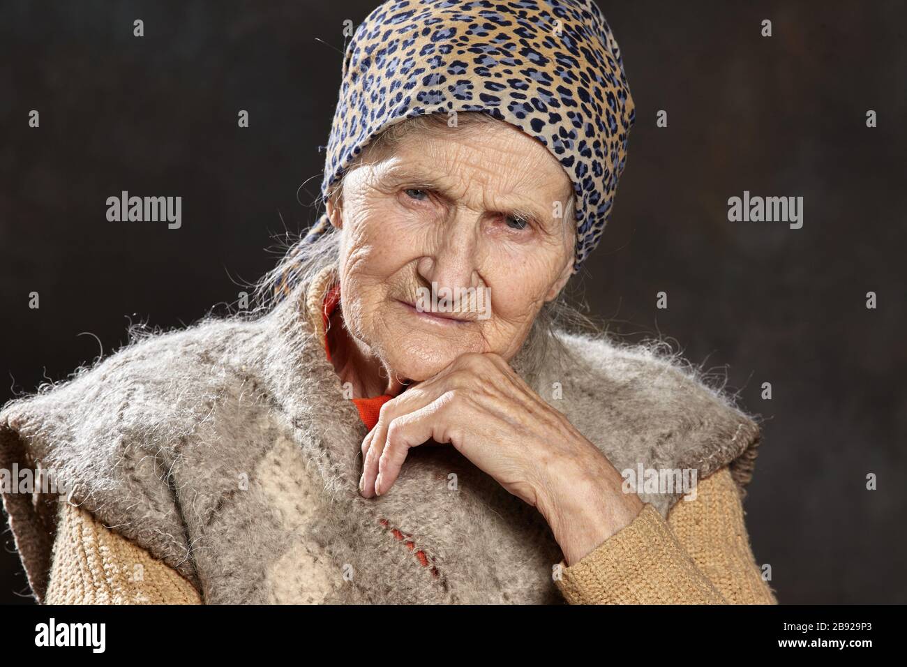 Nahaufnahme Porträt einer alten Frau mit nachdenklichen Blick auf dunklen Hintergrund. Menschen solchen Alters sind während Epidemien am anfälligsten. Stockfoto