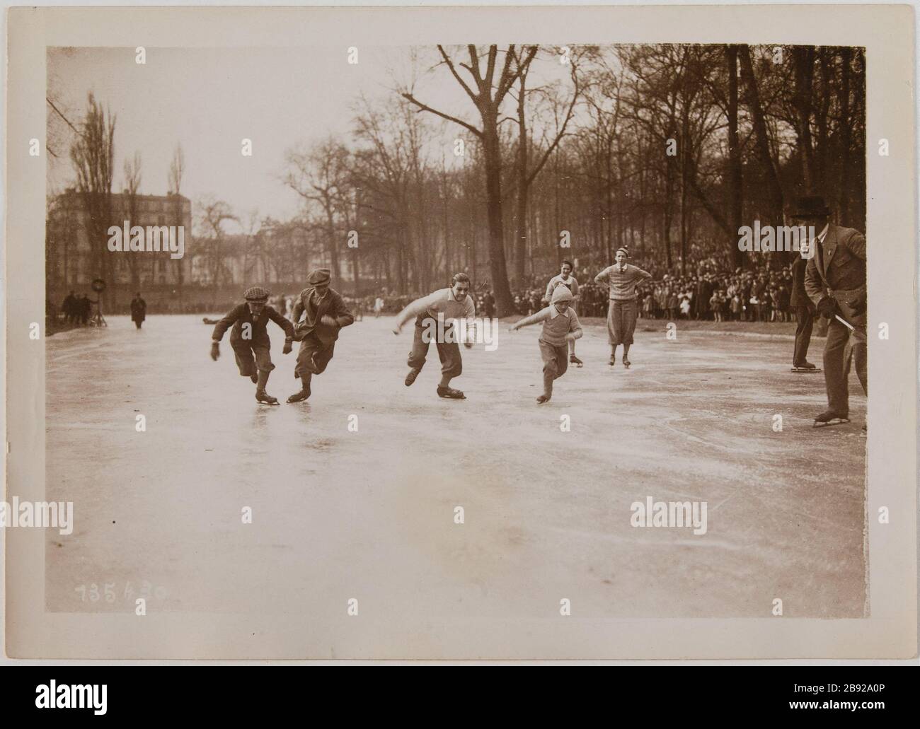 St. Mande / die Ausreise junger Leute laufen. Beginn eines Wettlaufs junger Menschen auf dem See Saint Mande, 12. Pariser Bezirk. Fête des Sports d'hiver. "DÉPART d'une course de jeunes gens sur le lac de Saint-Mandé, Paris (XIIème arr.)". Photographie de Georges Devred pour l'agence ROL. 1929. Paris, musée Carnavalet. Stockfoto