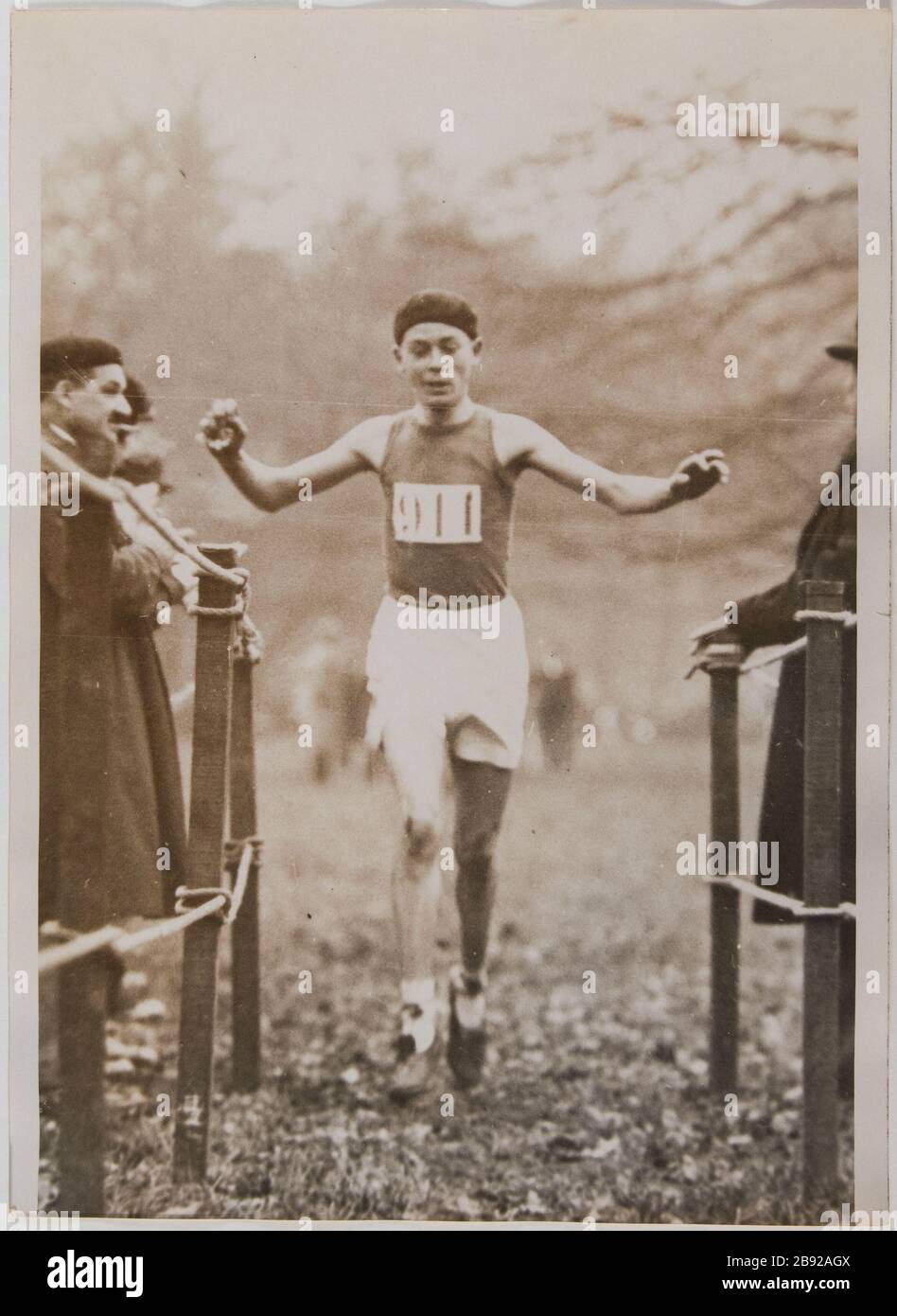 Ankunft von Roger Rochard, Gewinner der Kreuzjugend beim jährlichen Kreuz der kompromisslosen Mannschaft, des Bois de Boulogne, 16. Bezirk, Paris. Dezember 1930. Arrivée de Roger Rochard, vainqueur du Cross des Jeunes lors du Cross annuel de l'Intransigeant. Boulogne. Paris (XVIème arr.)". Photographie de Georges Devred pour l'agence ROL, 21 décembre 1930. Paris, musée Carnavalet. Stockfoto