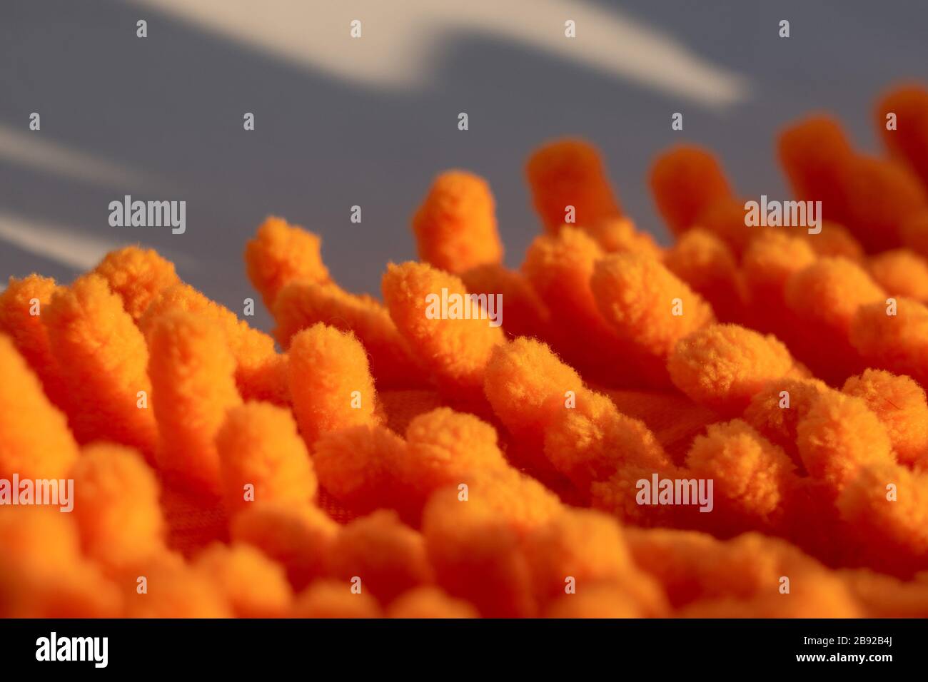 Mikrofaserstruktur mit einem weichen, großen Haufen. Oberflächenstruktur aus orangefarbenem Mikrofasertuch Stockfoto