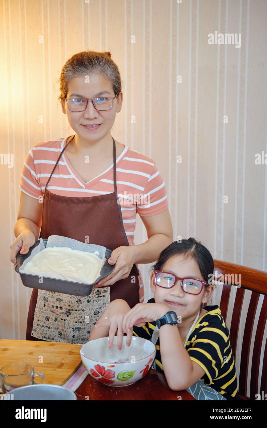 Mutter und Tochter mit Kuchen im Backblech Stockfoto