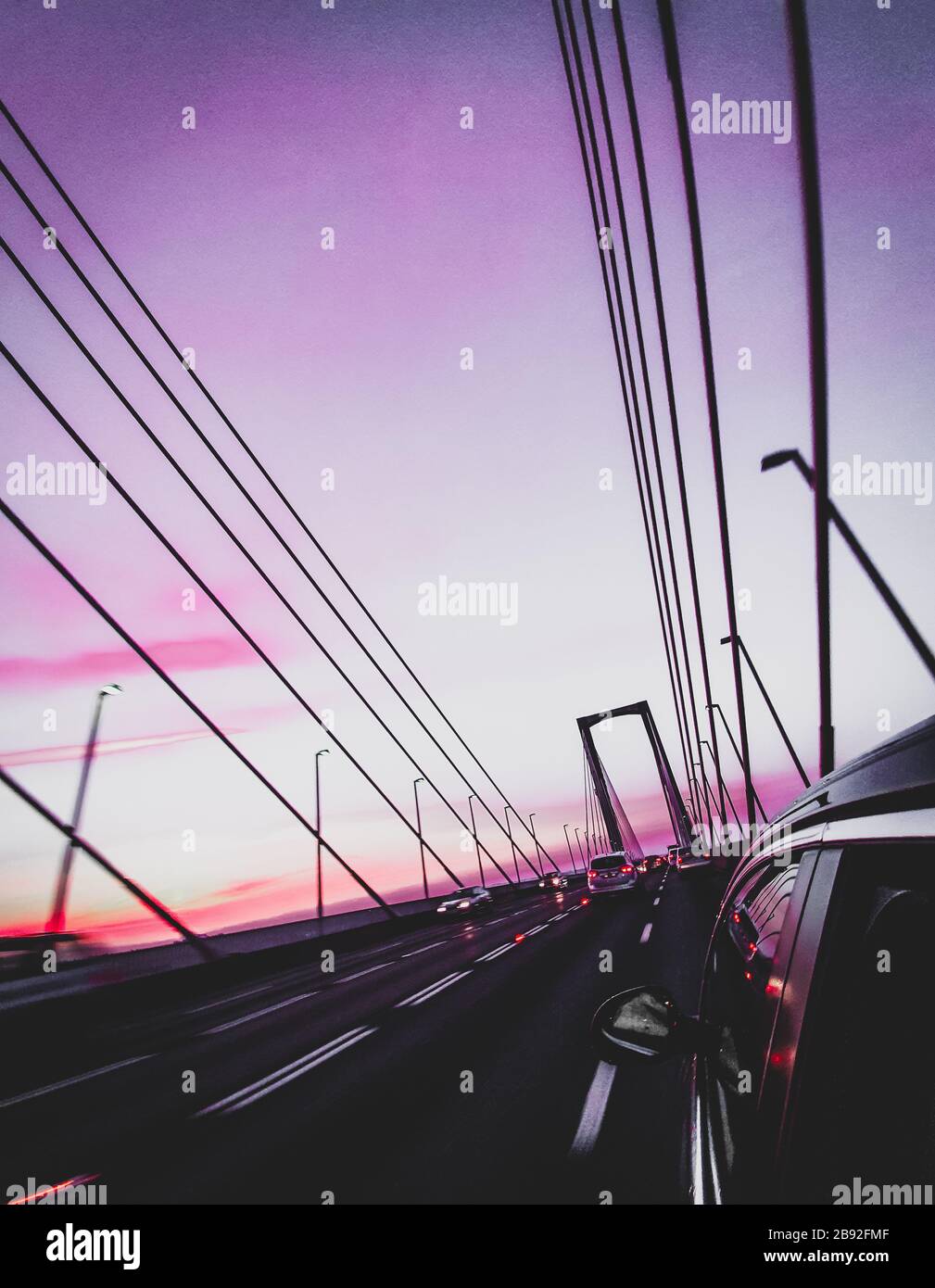 Lila Sonnenuntergang Himmel. Atardecer cielo morado en el Puente del Centenario. Stockfoto