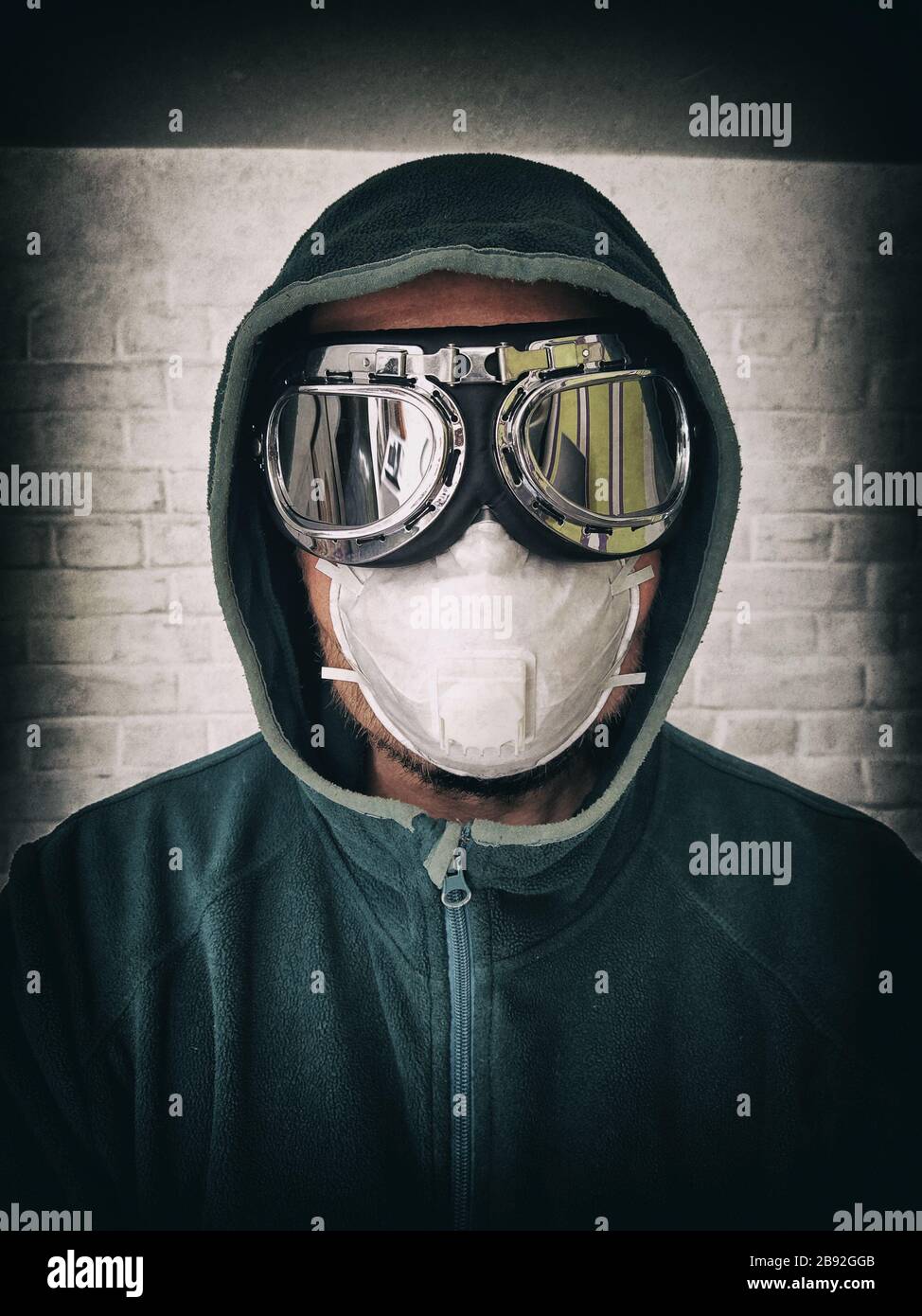 Porträt eines Mannes in Schutzmaske und Spiegelgläser. Stilisiertes Porträt eines pandemischen Gesichts Stockfoto