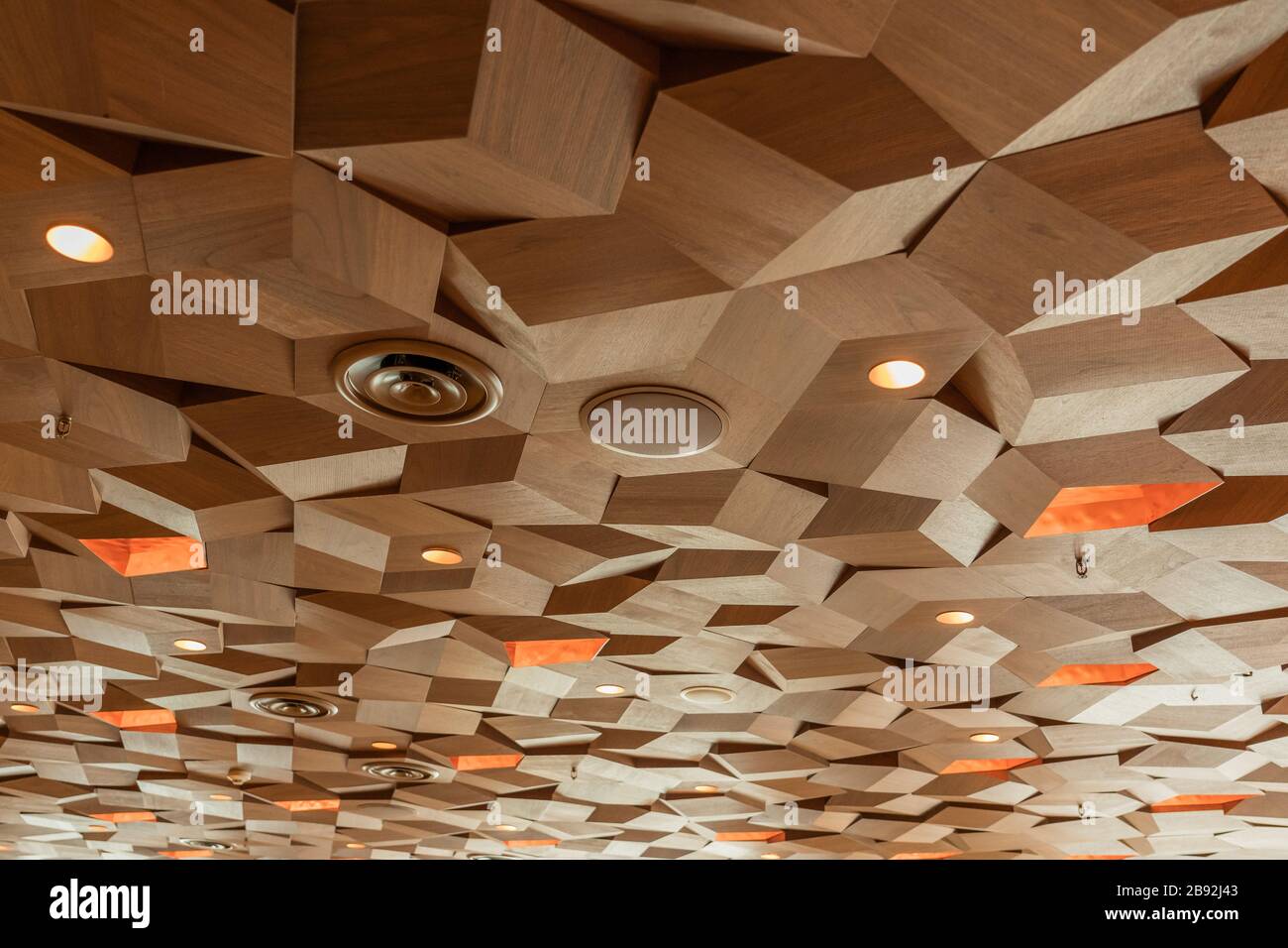 Lichter Lautsprecher Belüftung und Brandsprinkler an der Decke Holztexturplatten. Sechskant-Holzplatten Aus Metall. Dreidimensionale Würfelform Decora Stockfoto