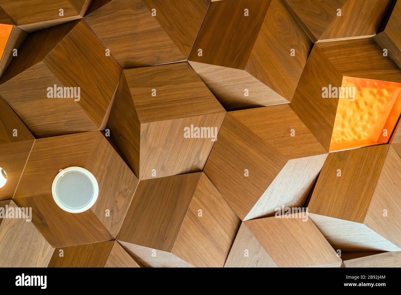 Lichter und Lautsprecher fallen Decke Holztexturfliesen ab. Sechskant-Holzplatten Aus Metall. Dreidimensionale Cube Form Dekoration. Untere Ansicht. Stockfoto