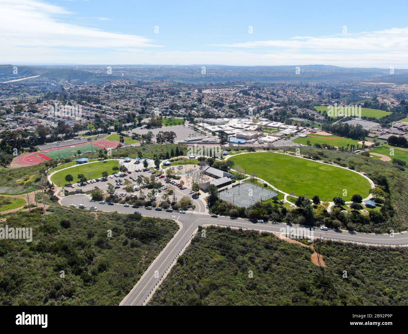 Blick auf den kleinen Gemeinschaftspark mit Spielplatz für Kinder im oberen Mittelklasse-Viertel mit Wohnunterteilhäusern am sonnigen Tag in San Diego, Kalifornien, USA. Stockfoto