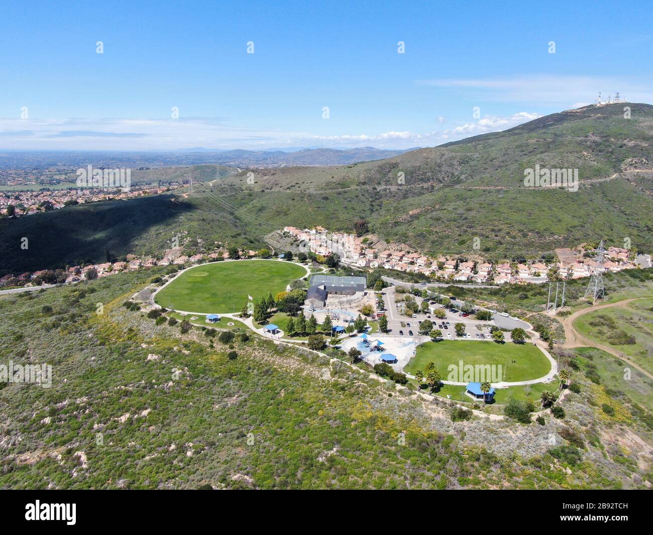 Blick auf den kleinen Gemeinschaftspark mit Spielplatz für Kinder im oberen Mittelklasse-Viertel mit Wohnunterteilhäusern am sonnigen Tag in San Diego, Kalifornien, USA. Stockfoto