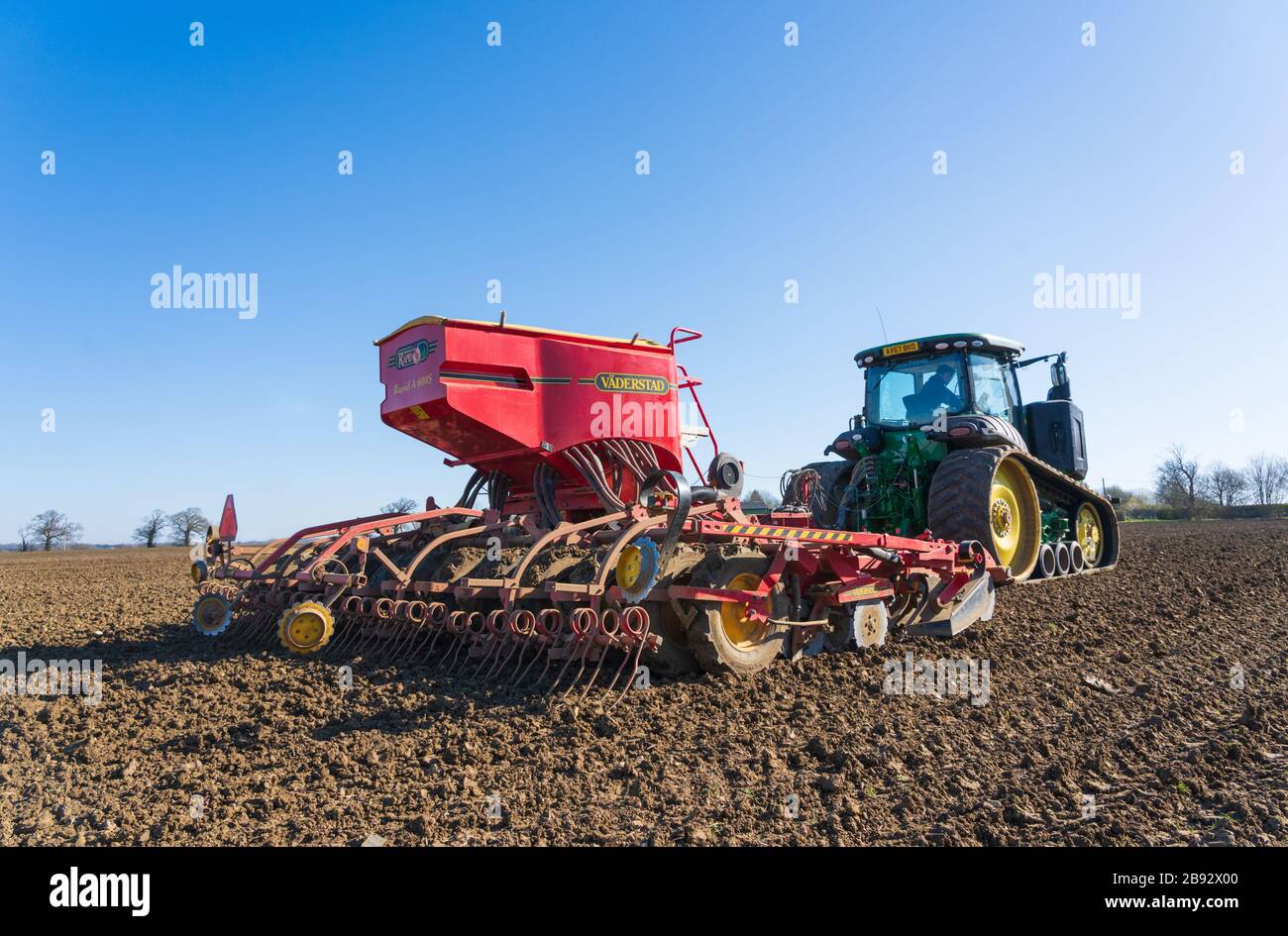 Traktor Aussaat Samen auf einem Feld im Frühjahr. Viel Hadham, Hertfordshire. VEREINIGTES KÖNIGREICH Stockfoto