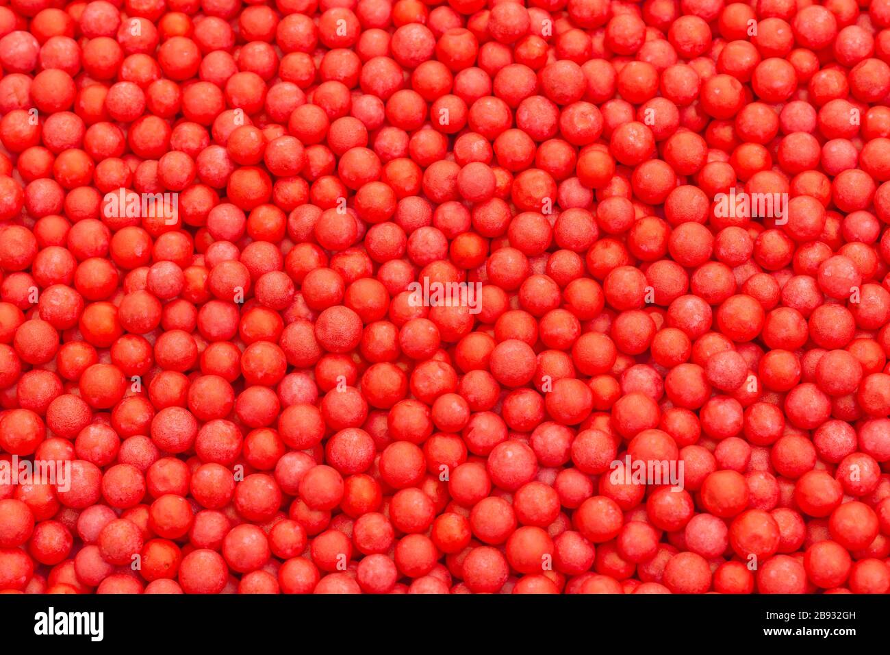 Farbige kleine rote Polystyrolkugeln. Konzept für Covid-19 Selbstisolation, Krankheitsträger, infizierte Person, isoliert, in der Menge verloren, abstrakt. Stockfoto