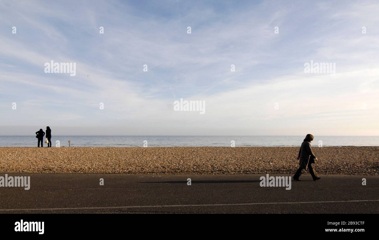 AJAXNETPHOTO. WORTHING, WEST SUSSEX, ENGLAND. - STRANDWANDERER - AM STRAND ENTLANG, WÄHREND EIN PAAR AUF DAS MEER BLICKT. FOTO: JONATHAN EASTLAND/AJAX REF:D122603 2217 Stockfoto