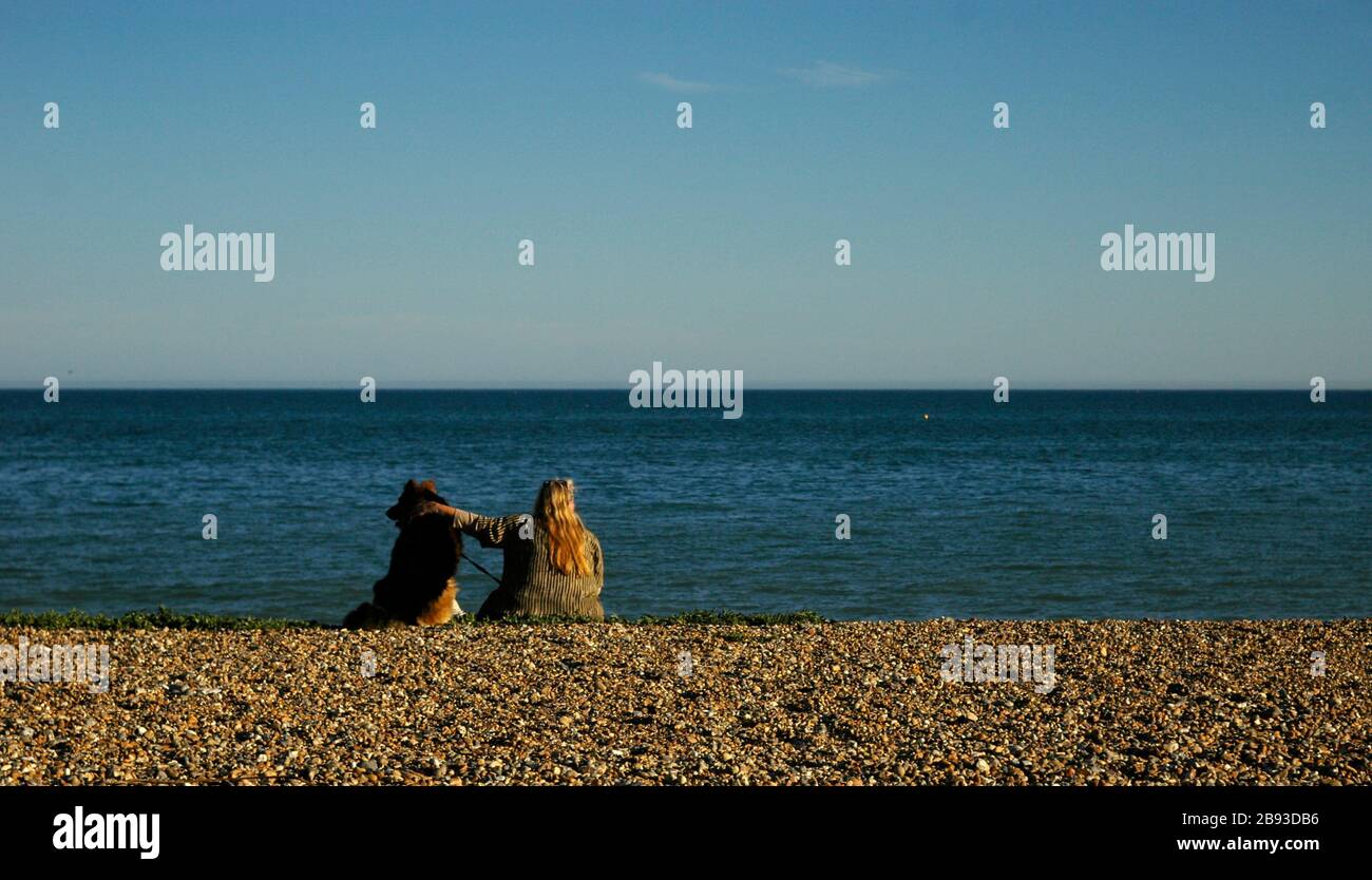 AJAXNETPHOTO. WORTHING, WEST SUSSEX, ENGLAND. - SEELUFT PUSCH - EIN HUND UND SEIN BESITZER NEHMEN DIE MEERESLUFT AM STRAND.FOTO: JONATHAN EASTLAND/AJAX REF:R110308 2087 Stockfoto