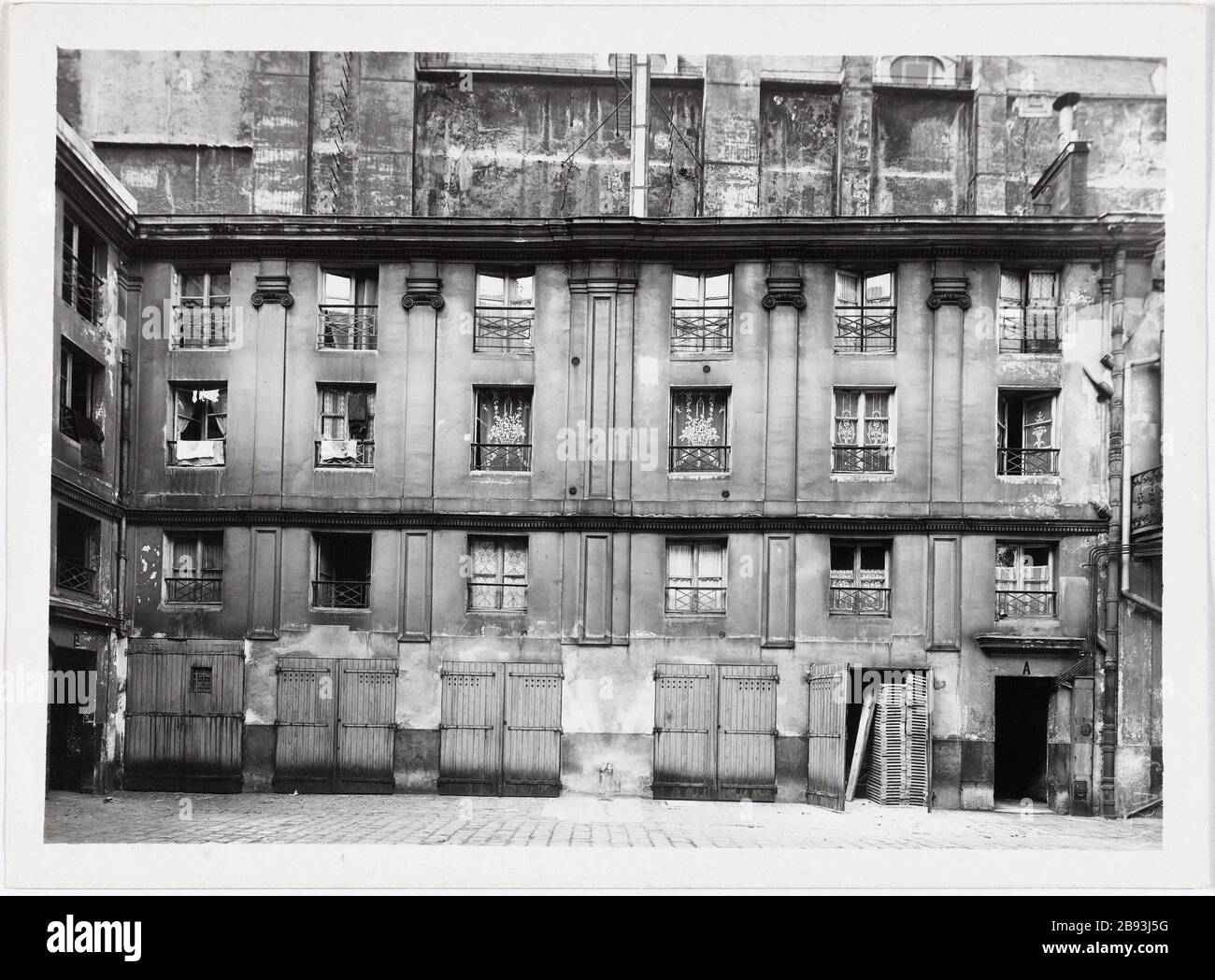 Rue St Antoine 2. Innenhof / # 111. Gebäudefassade, doppelte Holztüren im Erdgeschoss façade Volutenkapitelle, 11 Rue Saint-Antoine, 4. Bezirk, Paris. "Cour, 111 rue Saint-Antoine, Paris (IVème arr.)". Photographie d'Albert Cayeux. Tirage au gélatinobromure d'argent. Entre 1941 und 1943. Paris, musée Carnavalet. Stockfoto