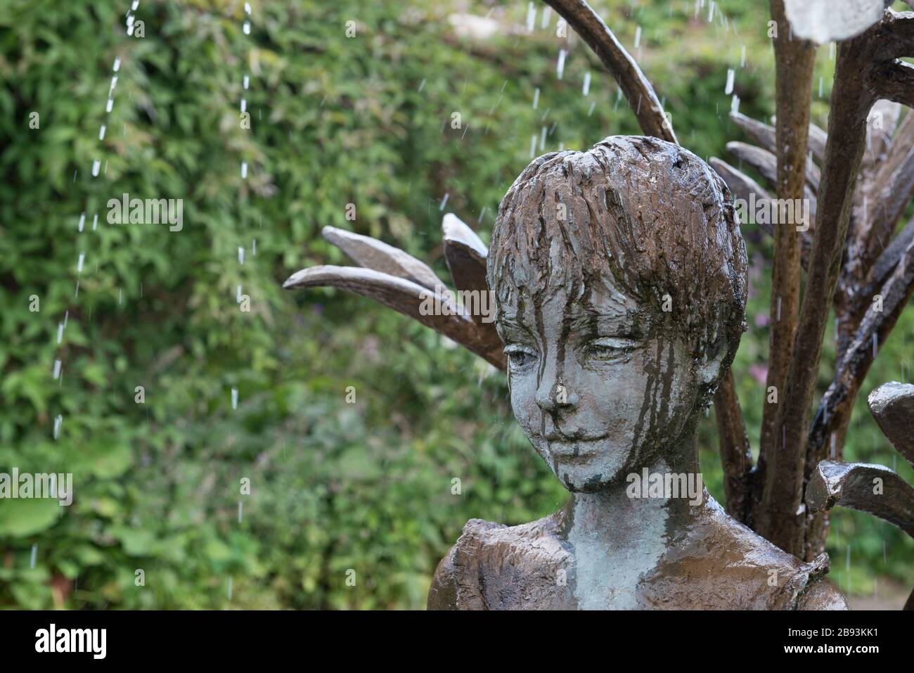 Skulptur eines lächelnden jungen Mädchens, das Teil eines Wassermerkmals im Garten in der Burton Agnes Hall in East Yorkshire ist Stockfoto