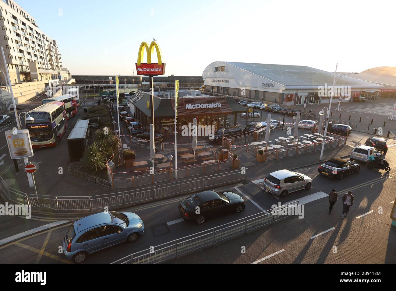 Brighton, Großbritannien. März 2020. McDonalds Drive-Thru-Kunden, die dort kurz vor dem Schließen des Fast-Food-Restaurants Autos anstehen, sind wegen des Coronavirus Ausbruchs in der Tür. Credit: James Boardman/Alamy Live News Stockfoto