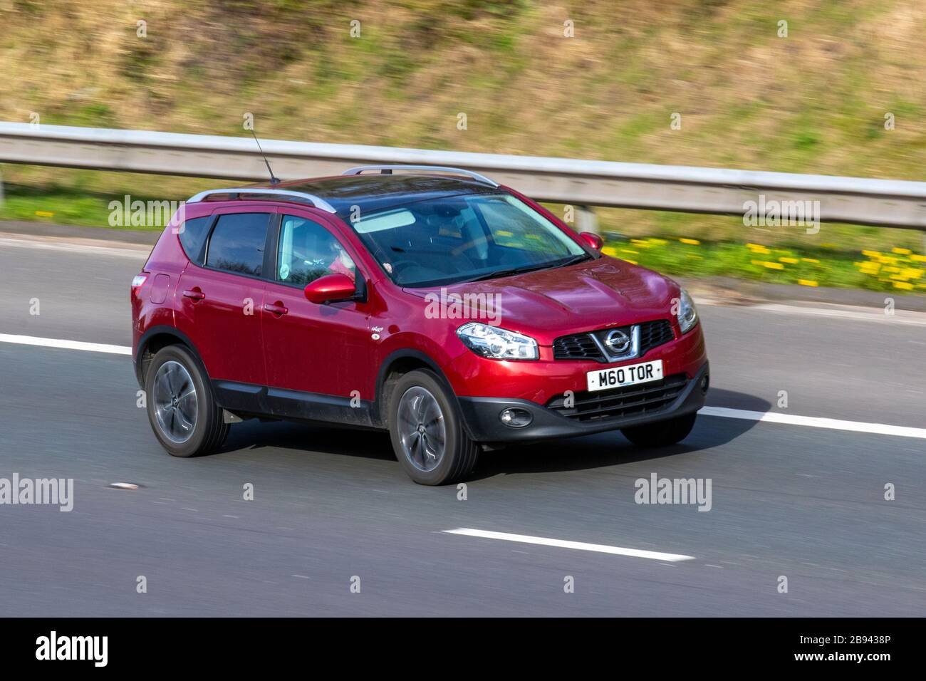 2012 rot Nissan Qashqai N-TEC +; UK Fahrzeugverkehr, Straßentransport, moderne Fahrzeuge, Limousinen, Autofahren, Straßen und Motoren, Autofahren in südlicher Richtung auf der Autobahn M61 Stockfoto
