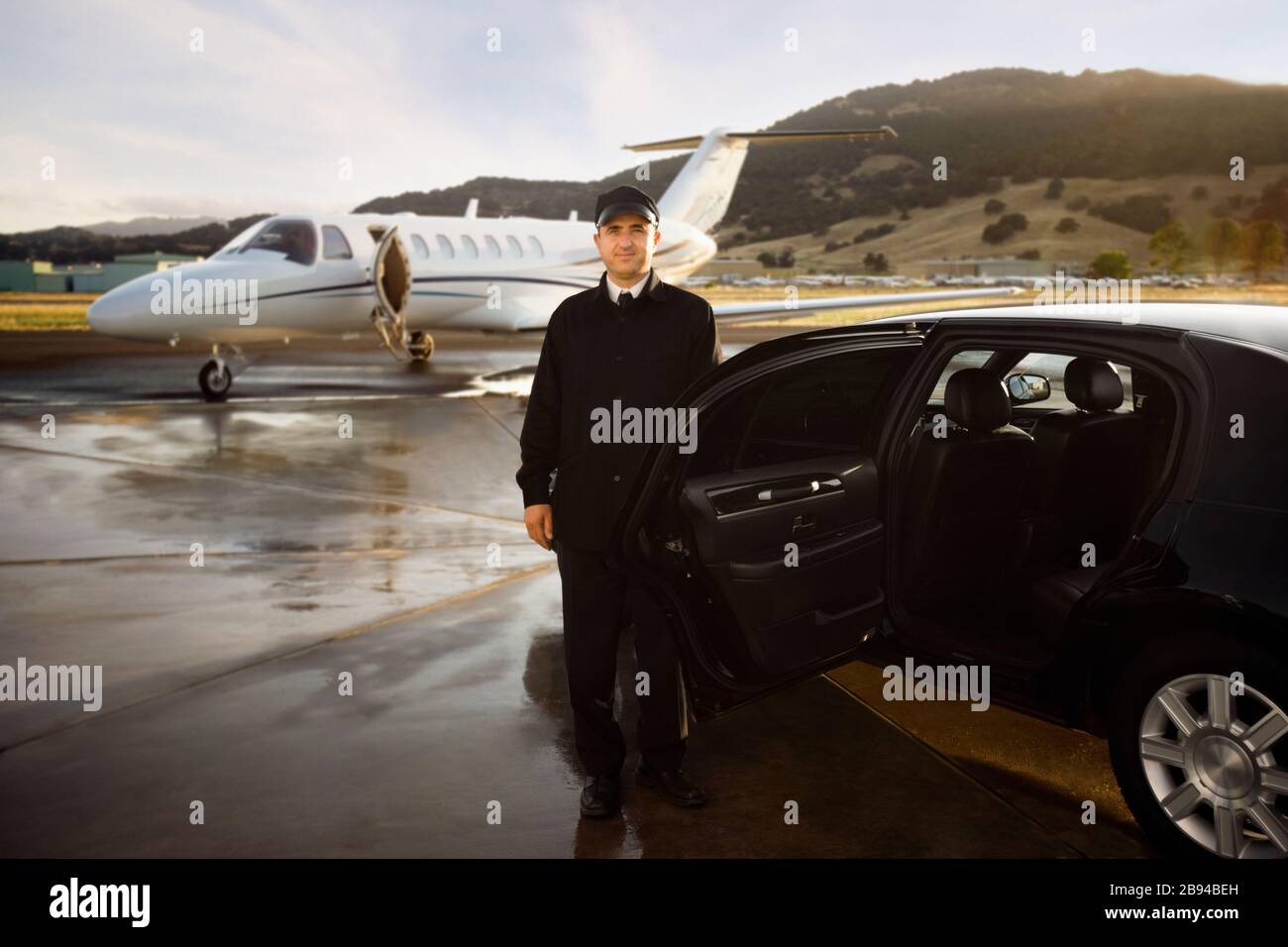 Chauffeur steht mit einem Auto am Flughafen Stockfoto