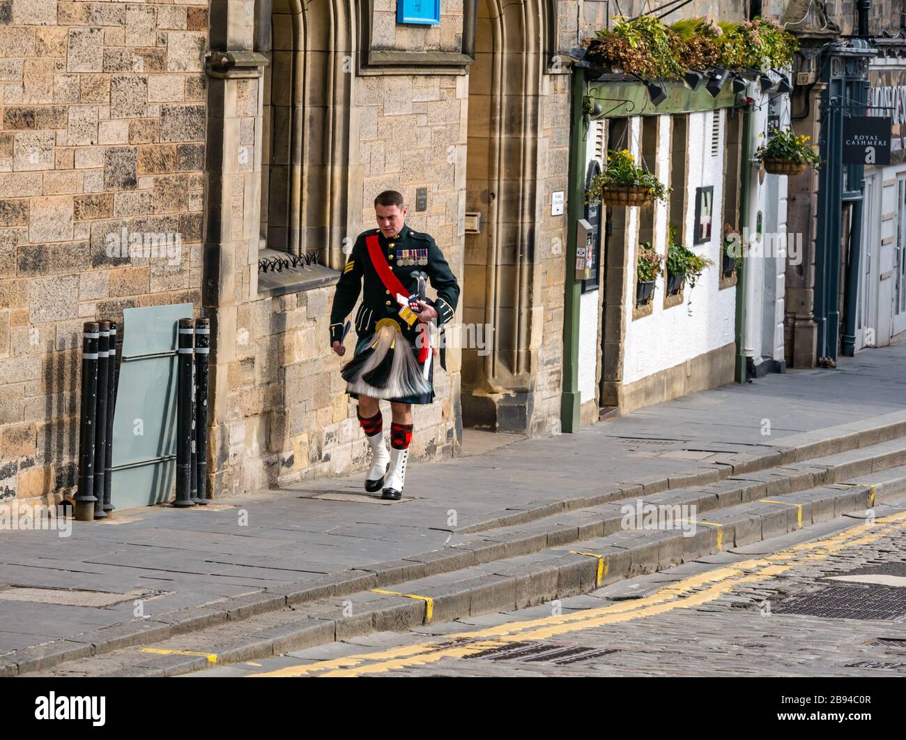 Mann in Kilt Uniform auf ungewöhnlich ruhiger Royal Mile während der Covid-19 Coronovirus-Pandemie, Edinburgh, Schottland, Großbritannien Stockfoto