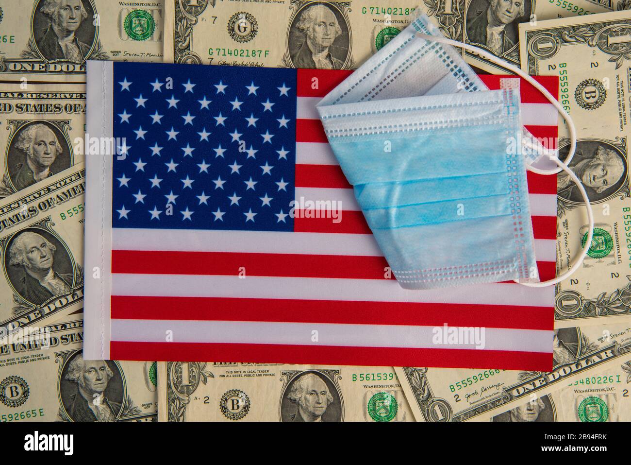 Amerikanische Flagge mit Virusschutzmaske auf US-Dollar Coronavirus Wirtschaftskrise Stockfoto
