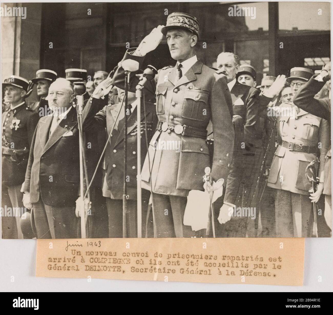 Fotografie-Propaganda: General Delmotte, Generalsekretär der Verteidigung bei der Aufnahme von Gefangenen, die in Compiègne Trampus repatriiert wurden. "Photographie propagande: Le général Delmotte, secrétaire général à la Défense, au Garde à vous durant l'accueil des prisonniers rapatriés à Compiègne". UN nouveau convoi de prisonniers rapatriés est / arrivé à COMPIEGNE où ils ont été accueillis par le / Général DELMOTTE, secrétaire Général à la Défense. Tirage au gélatino-bromure d'argent. Légende dactylographiée à l'encre noire. En 1943-06-11-1943-06-11. Paris, musée Carnavalet. Stockfoto