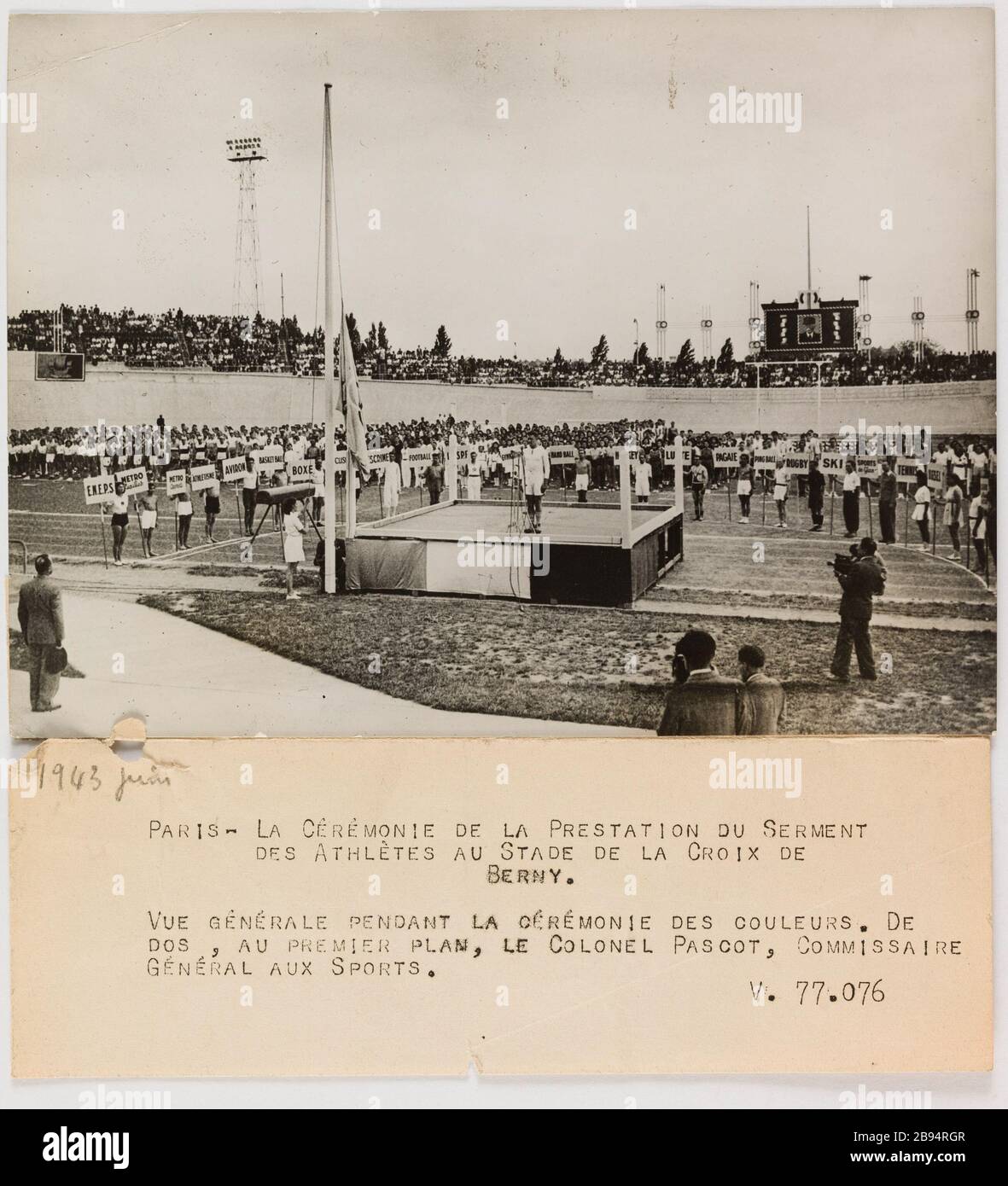 Fotografie-Propaganda-Zeremonie zur Eidesleistung der Athleten auf der Bühne des Croix de Berny, Antony. Trampus. "Photographie propagande: Cérémonie de la prestation du serment des athlètes au stade de la Croix de Berny, Antony". PARIS - LA CEREMONIE DE LA PRESTATION DU SERMENT / DES ATHLETES AU STADE DE LA CROIX DE / BERNY. / VUE GENERALE PENDANT LA CEREMONIE DES COULEURS. DE/DOS, AU PREMIER PLAN, LE COLONEL PASCOT, COMMISSAIRE / GENERAL AUX SPORTS. Tirage au gélatino-bromure d'argent. Légende dactylographiée à l'encre noire. En 1943-06-29-1943-06-29. Paris, musée Carnavalet. Stockfoto