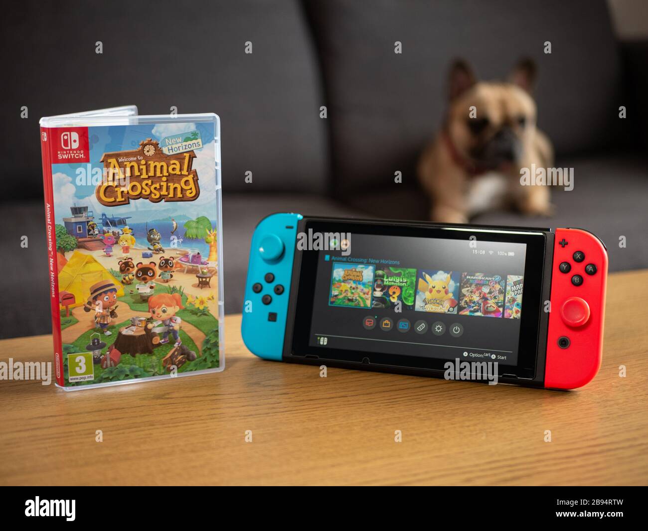 Großbritannien, März 2020: Nintendo Switch mit Animal Crossing neuen Horizonten Startbildschirm mit Hund dahinter Stockfoto