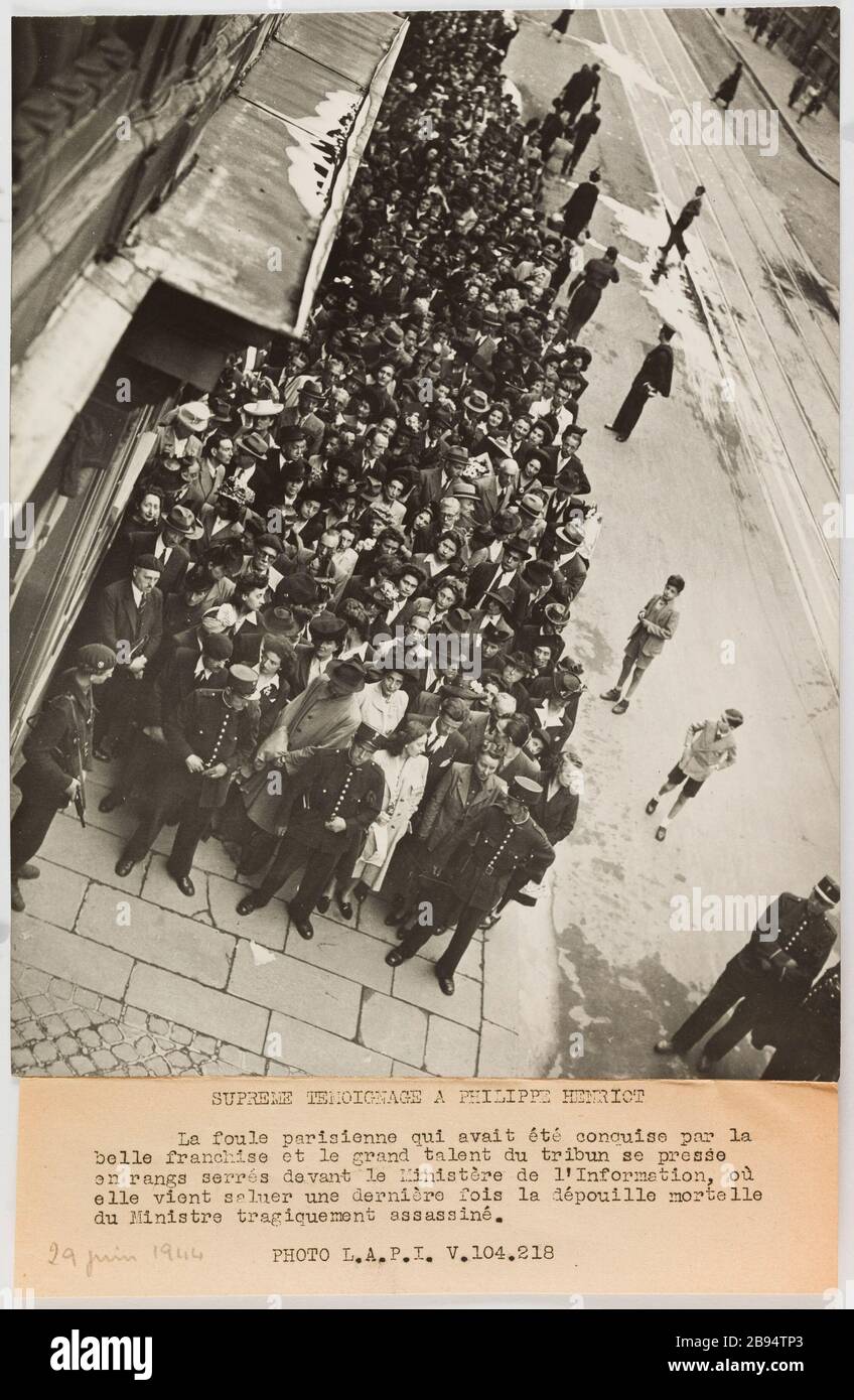 Fotografie-Propaganda-Menge, die den Leichnam eines ermordeten Ministers grüßt. Agence LAPI (Les Actualités Photographiques Internationales). "Photographie propagande: Foule venant saluer la dépouille d'un ministre assiné". SUPREME TEMOIGNAGE A PHILIPPE Henriot / La Foule parisienne qui avait été conquise par la / belle Franchise et le Grand Talent du Tribun se presse / en rangs serrés devant le Ministère de l' Information, où / elle vient saluer une dernière fois la dépouille mortelle / du Ministre tragiquement assassiné. / FOTO L.A.P.I. V. 104.218. Tirage au gélatino-bromure d'argent. Lég Stockfoto