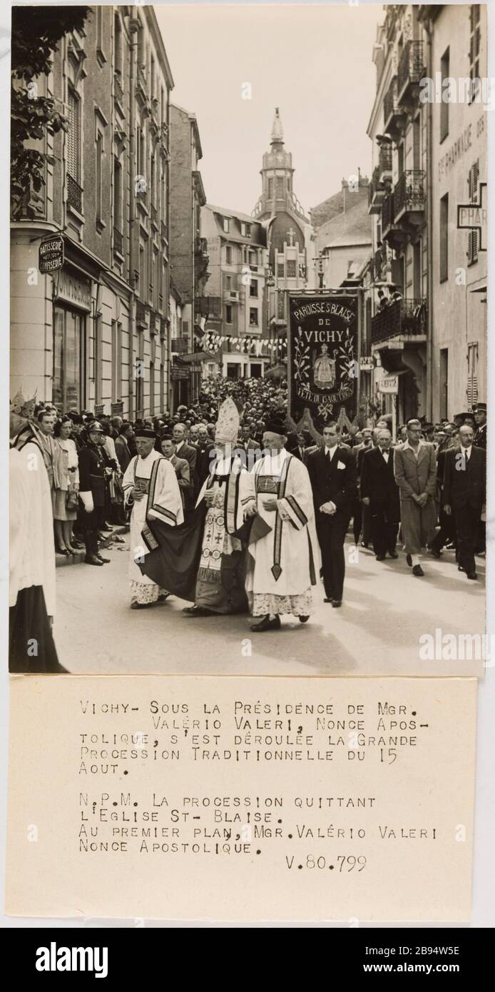 Fotografie-Propaganda-Prozession der Jungfrau, Vichy Trampus. "Photographie propagande: Procession de la Vierge, Vichy". Vichy - sous la Présidence de Mgr. / Valéro Valeri, nOnce apos- / tolique, s'est déroulée la Grande / Procession traditionnelle du 15 / Aout. / N.P.M. La Procession quitant / l'Eglise St- Blaise. / Premier-Plan Au, Mgr. Valerio Valeri/Nonce Apostolique. / V.80.799. Tirage au gélatino-bromure d'argent. Légende dactylographiée à l'encre noire. En 1943-08-16-1943-08-16. Paris, musée Carnavalet. Stockfoto