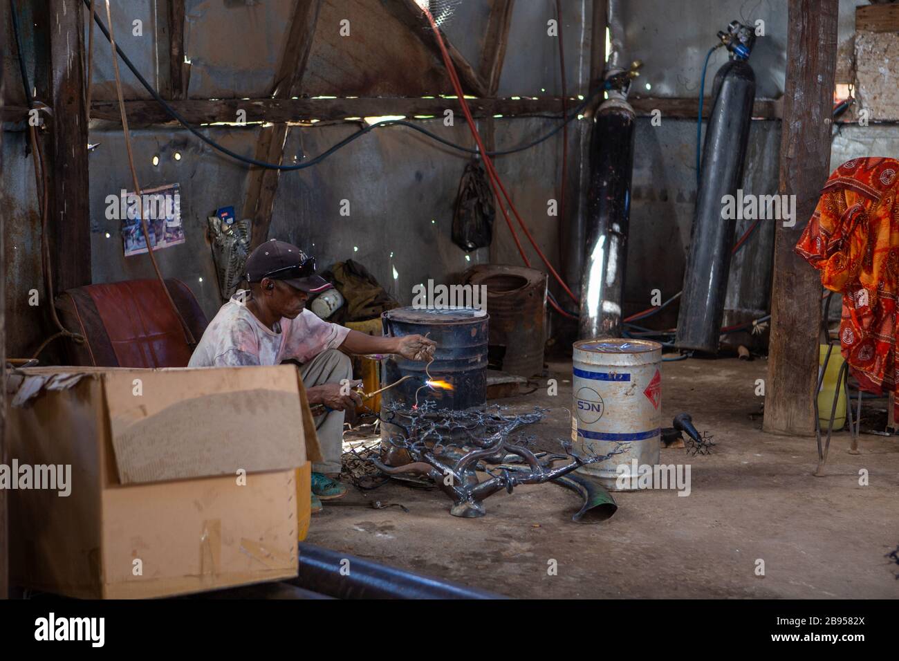 Schweißer im sozialen und solidarischen Unternehmen der Metallverarbeitung mit recyceltem Material, das von Violette und Dieudonne in Antananarivo hergestellt wurde Stockfoto