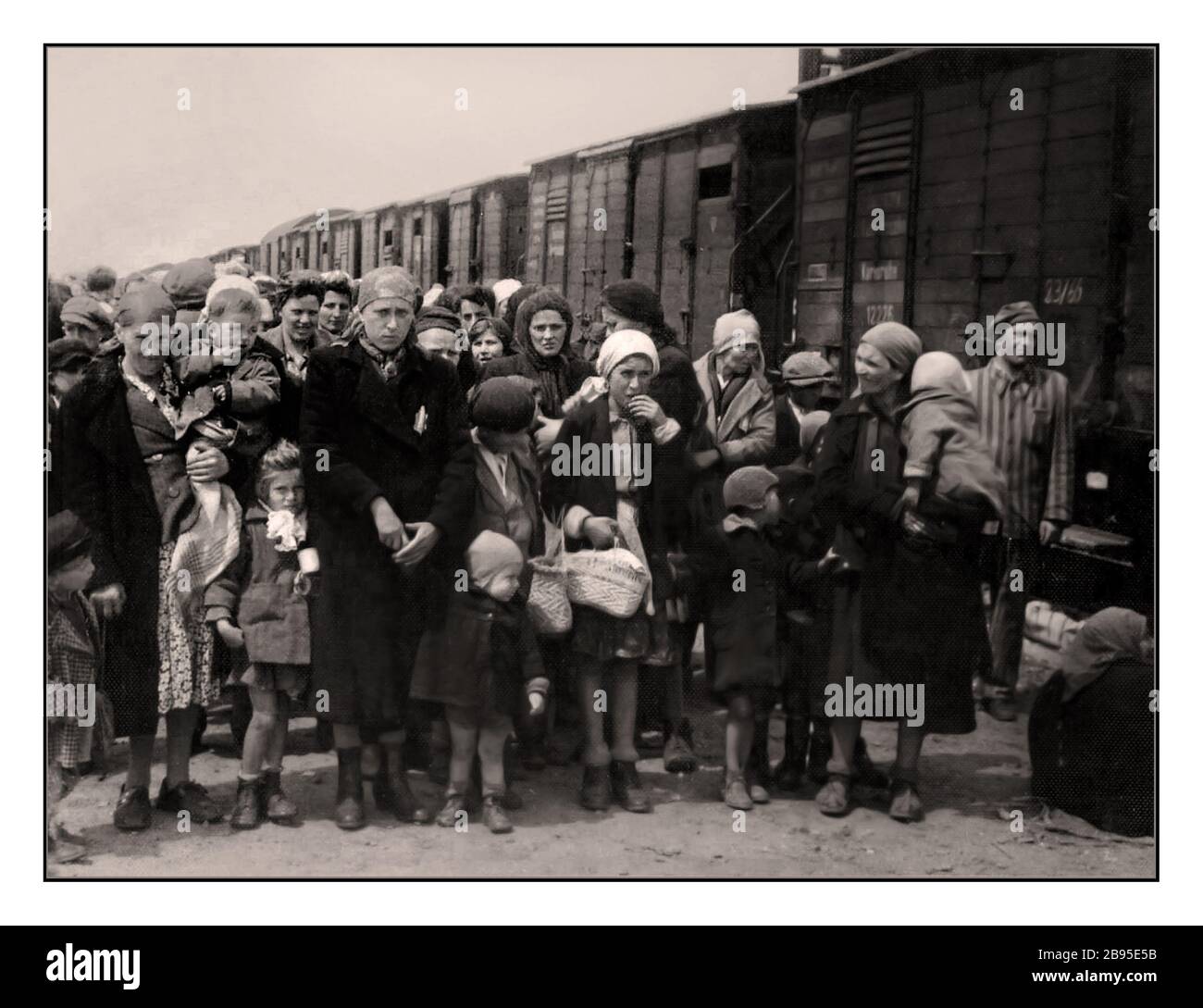 Ankunft Auschwitz-Birkenau. Jüdische Frauen und Kinder einige tragen die gelben Nazi-Sterne und kommen mit Viehzügen nach Auschwitz-Birkenau, einem WW2 errichteten deutschen Konzentrationslager der Nazis. Jüdische Kinder waren die größte Gruppe, die ins Lager deportiert wurde. Sie wurden Anfang 1942 zusammen mit Erwachsenen als Teil der „endgültigen Lösung der jüdischen Frage“ geschickt Die totale Zerstörung der jüdischen Bevölkerung Europas...das Konzentrationslager Auschwitz war ein Netz deutscher Konzentrations- und Vernichtungslager, die vom Dritten Reich in polnischen Gebieten betrieben wurden, die während des Zweiten Weltkriegs von Nazideutschland annektiert wurden Stockfoto