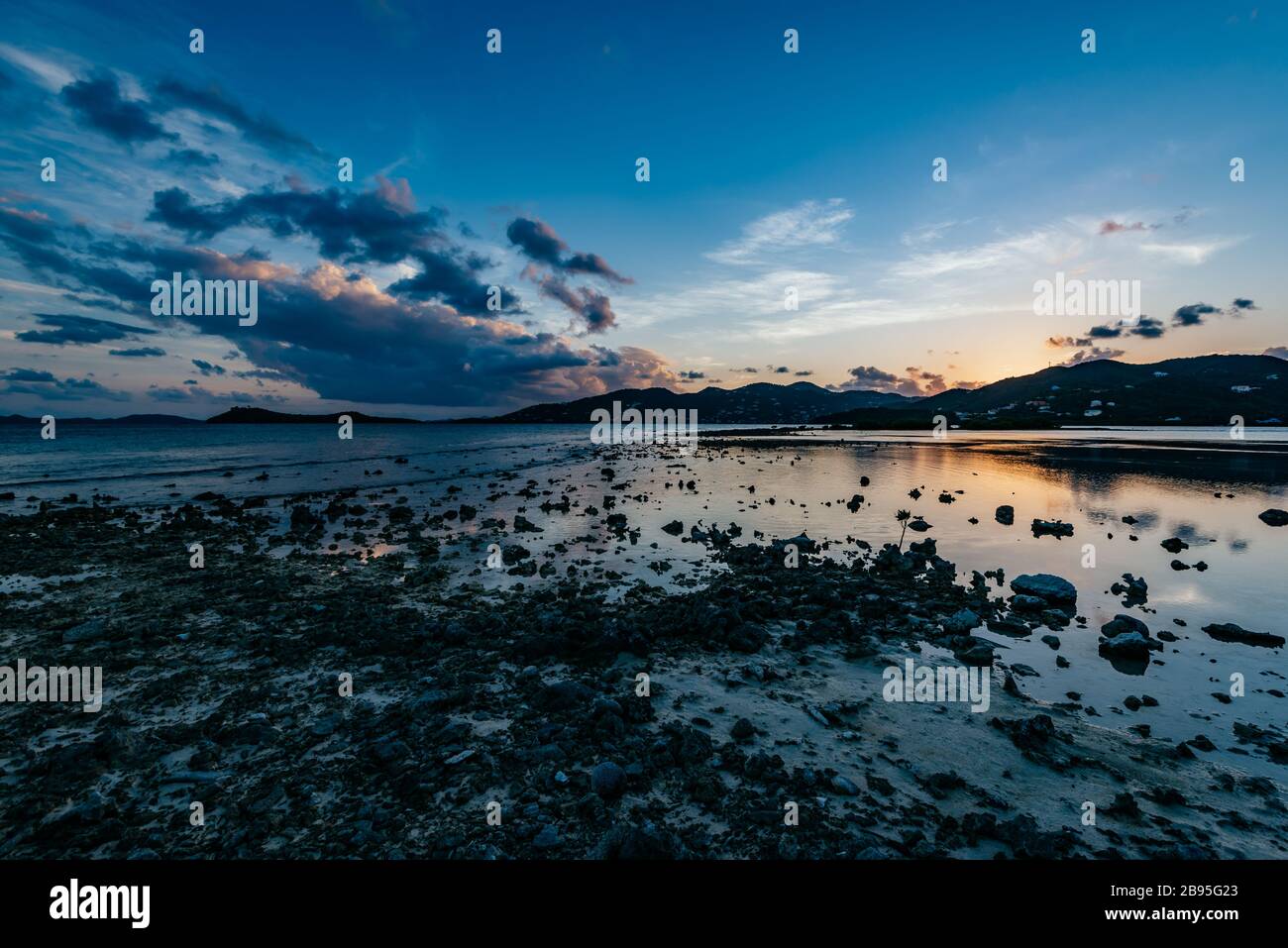 Die felsige Küste von Beef Island in der Abenddämmerung, mit Blick über die Well- und Bluffbuchten in Richtung Parham Town auf der Tortola-Insel, British Virgin Islands BVI Stockfoto