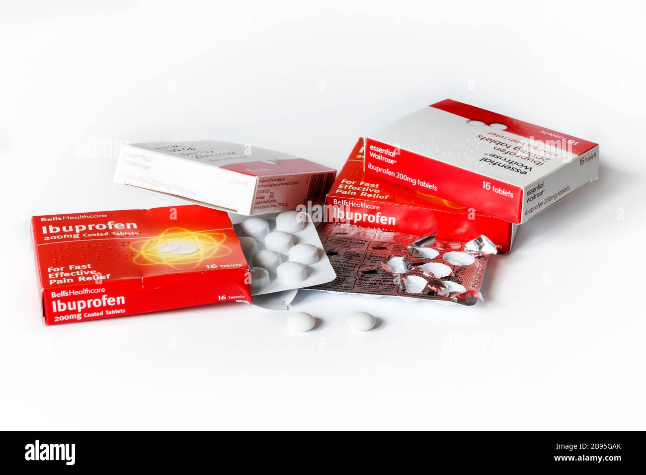 Faltschachteln mit Ibuprofen-Tabletten und Blisterpackungen, aus denen zwei Tabletten entfernt werden, auf weißem Hintergrund Stockfoto