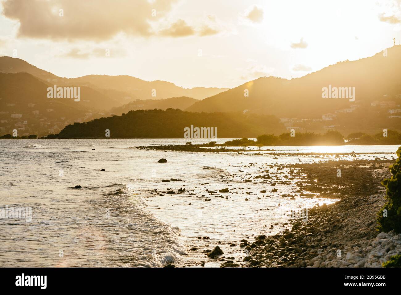 Die felsige Küste von Beef Island in der Abenddämmerung, mit Blick über die Well- und Bluffbuchten in Richtung Parham Town auf der Tortola-Insel, British Virgin Islands BVI Stockfoto