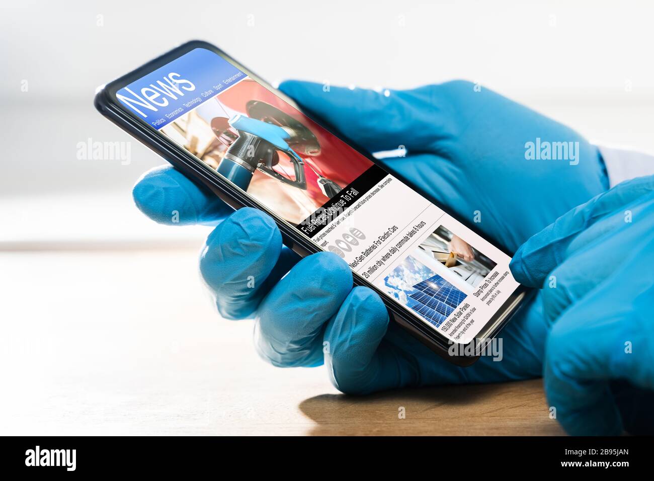 Mann Auf Quarantäne In Handschuhen Überprüfung Von Coronavirus Nachrichten Auf Handy Stockfoto