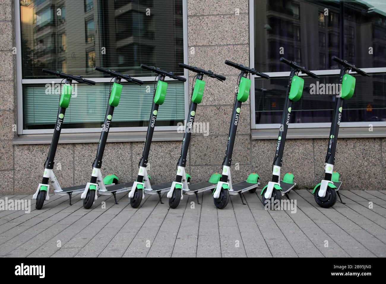 Während eines sonnigen Sommertags im städtischen Stadtzentrum von Helsinki wurden viele Roller mit Elektroverleih in Limette fotografiert. Trendige Art zu bewegen. Helsinki, FI. Stockfoto