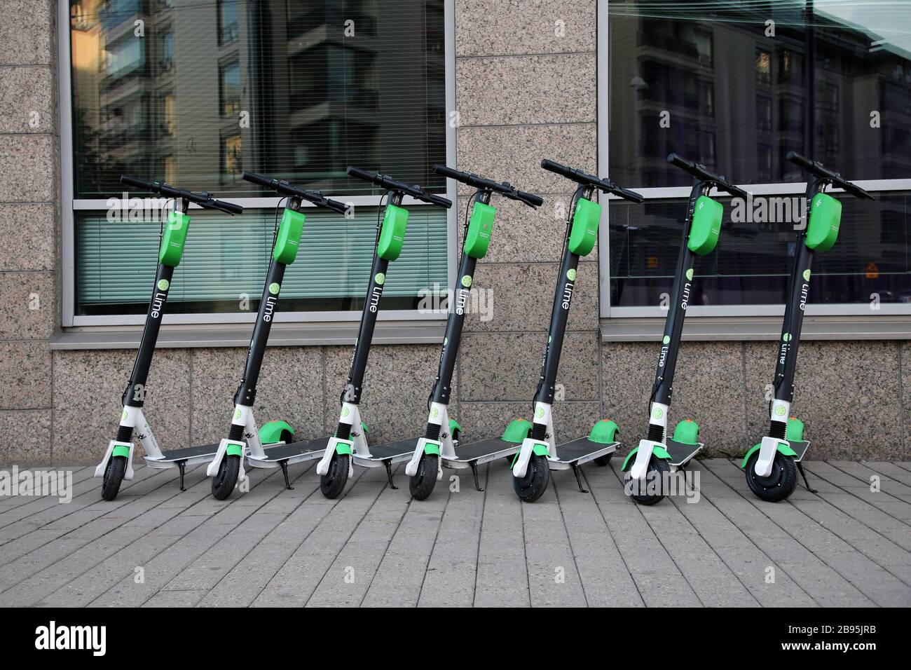 Während eines sonnigen Sommertags im städtischen Stadtzentrum von Helsinki wurden viele Roller mit Elektroverleih in Limette fotografiert. Trendige Art zu bewegen. Helsinki, FI. Stockfoto