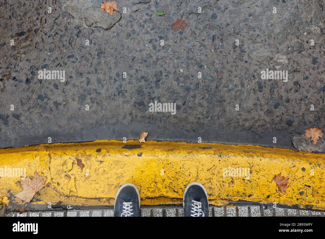 Füße auf gelb gestrichenen Seitenstreifen während eines Rainig Day in Buenos Aires Stockfoto