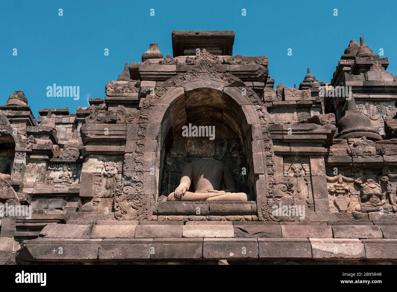 Buddha-Statue mit dem Kopf, der im Borobudur-Tempel in Indonesien fehlt. Buddha-Köpfe werden abgeschnitten und aus den Kolonialzeiten in Museen in Europa gebracht. Stockfoto