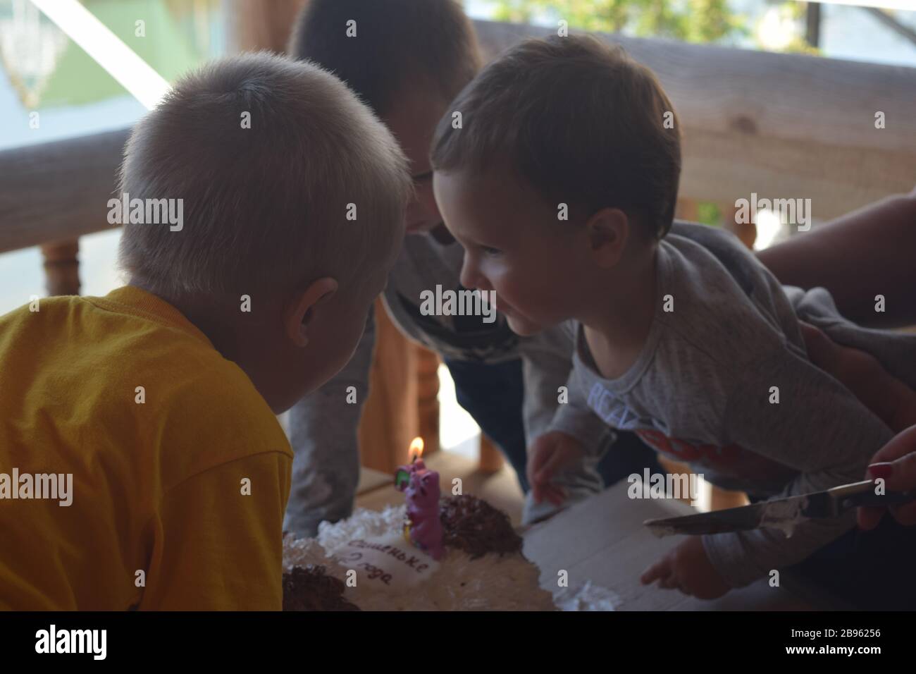 Jungs blasen die Kerze auf einem Geburtstagskuchen aus Stockfoto