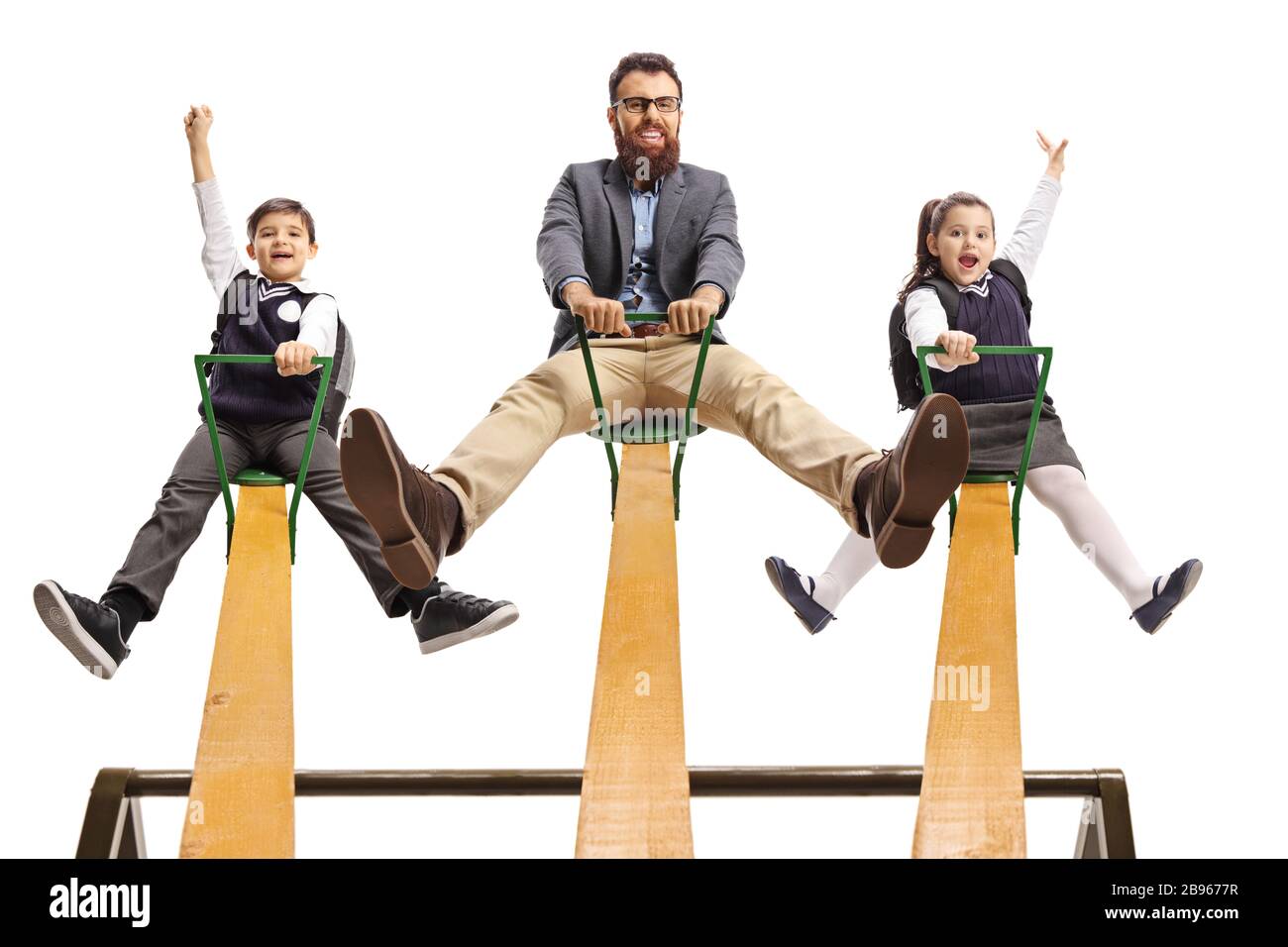 Männliche Lehrerin, die mit einem Schuljungen und einem Schulmädchen auf einem auf weißem Hintergrund isolierten Seesaw spielt Stockfoto