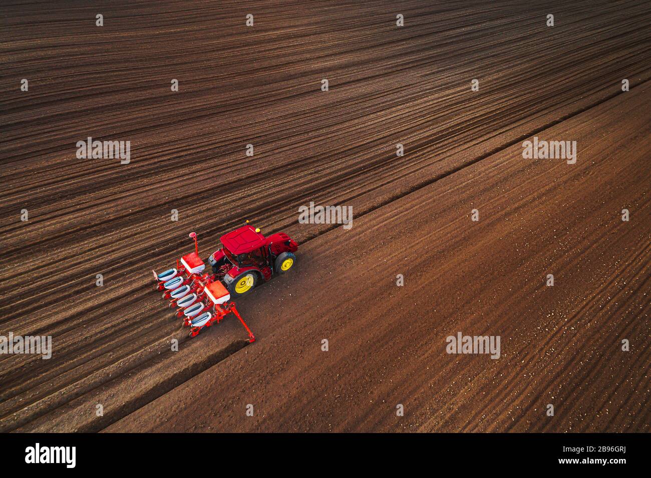 Bauer im Traktor vorbereiten Ackerland mit Saatgut für das nächste Jahr Stockfoto