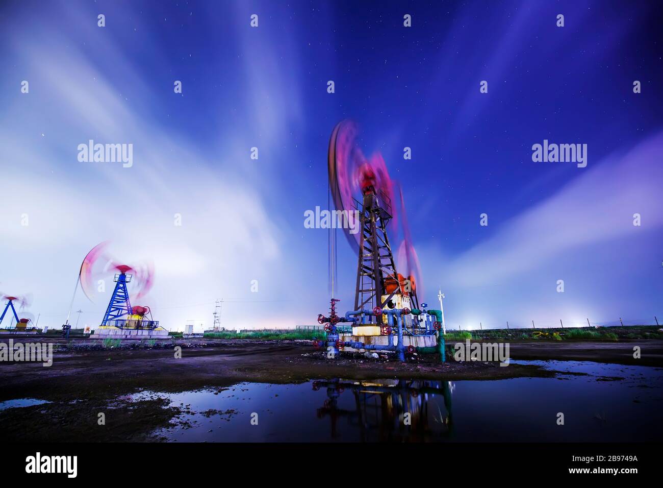 Die Ölpumpe und die Durchflusswolke am Abend Stockfoto