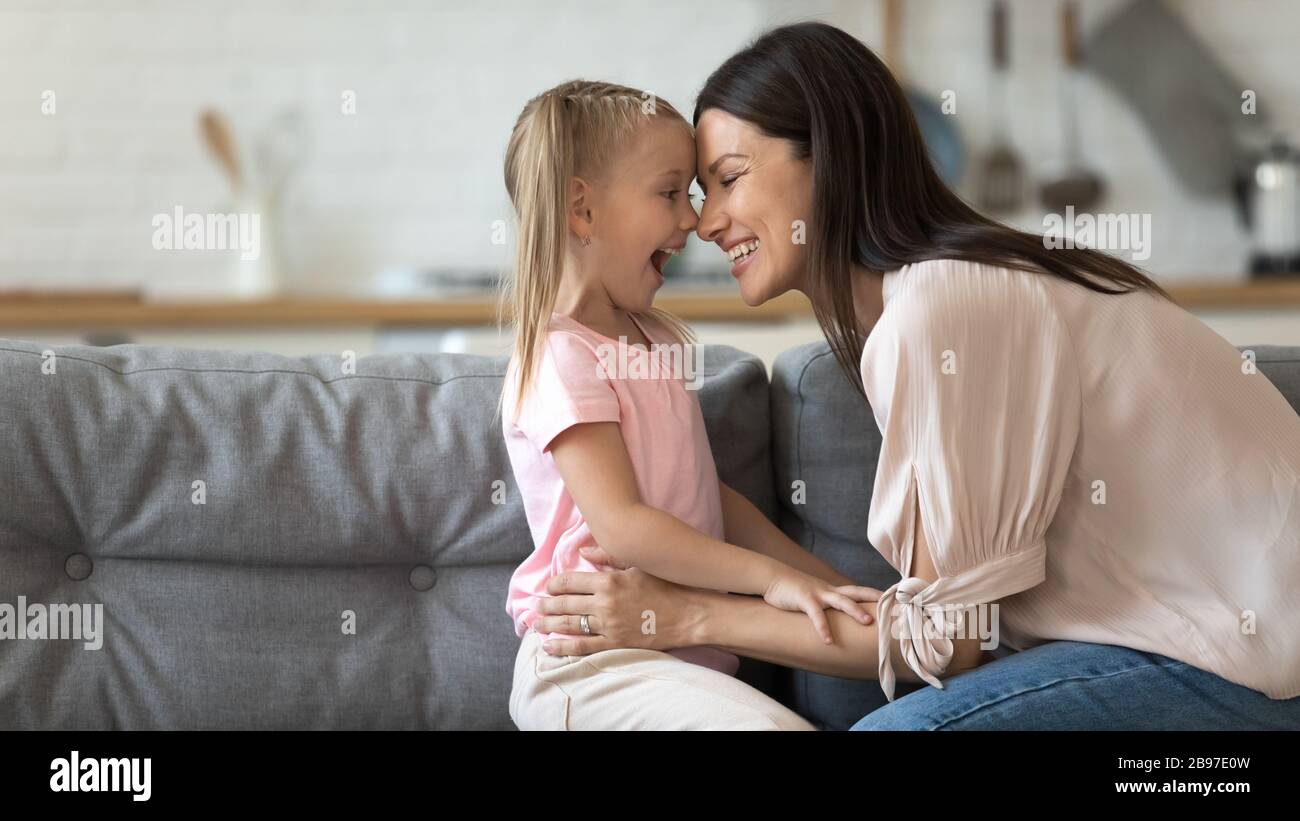 Lächelnde Mutter und Tochter kuscheln zu Hause Stockfoto