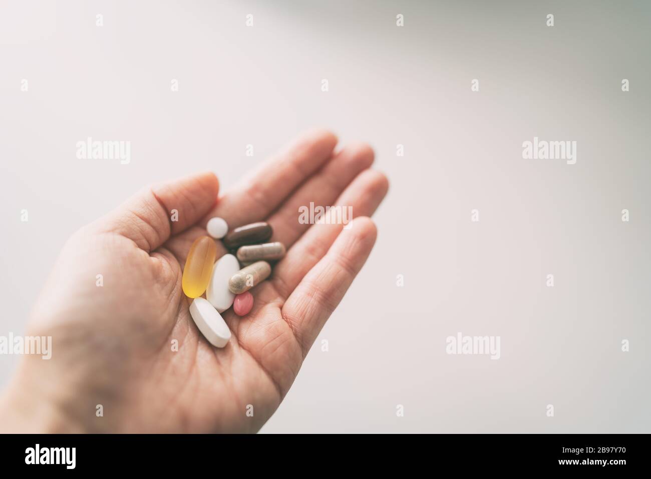 Vitamine, Mineralstoffe und Ergänzungen Pille Kapseln Frau unter vielen Pillen Draufsicht der Hand halten Tabletten Stockfoto