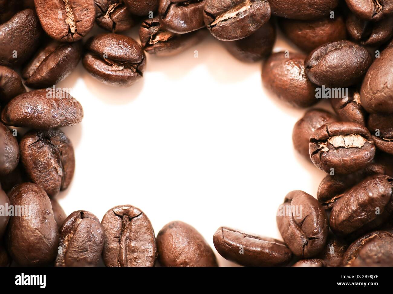 Bohnen - Kaffeesamen, die auf weißem Hintergrund verschüttet werden Stockfoto