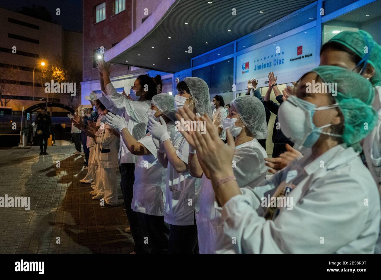 Medizinisches Personal klatschen sich am Eingang des Krankenhauses Fundación Jiménez Díaz in Madrid die Hände, um den Menschen zu danken, die sie bei der Bekämpfung von Coronavirus unterstützt haben. Jeden Tag, seit die Sperrstelle am 14. März eingerichtet wurde, nehmen Madrilenos auf ihren Balkon, um medizinisches Personal zu applaudieren und zu unterstützen, das gegen Coronavirus kämpft. Stockfoto