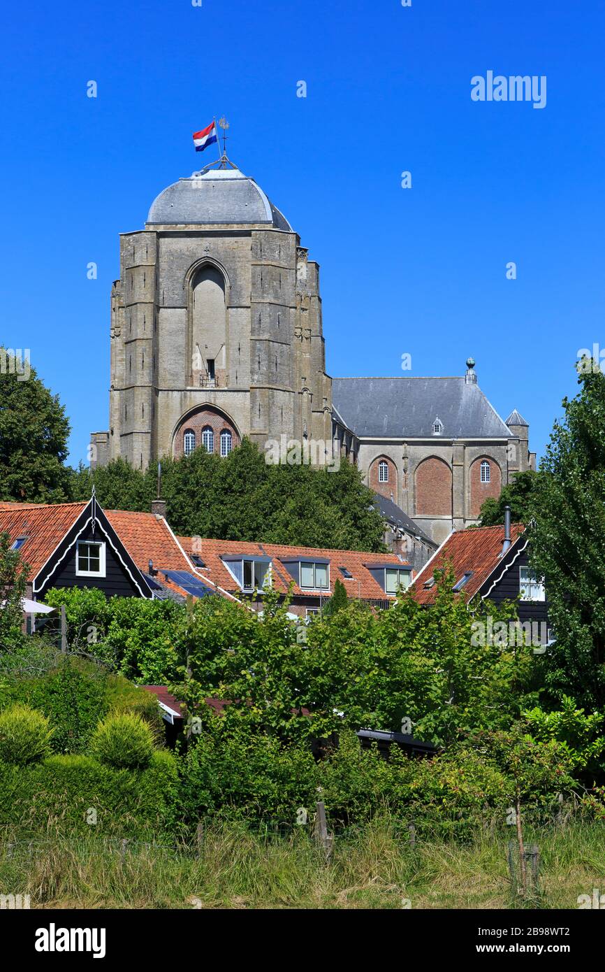Die niederländische Flagge stolz über die spätgotischen Kirche Unserer Lieben Frau - Grote Kerk (1450-1521) in Veere, Niederlande fliegen Stockfoto