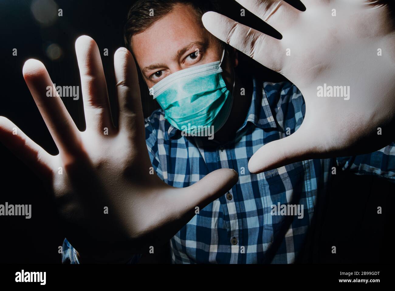 Affraid Mann Hände soziale Distanzierung mit medizinischen Handschuhen und Maske zum Schutz vor Corona-Virus Kovid-19 Stockfoto