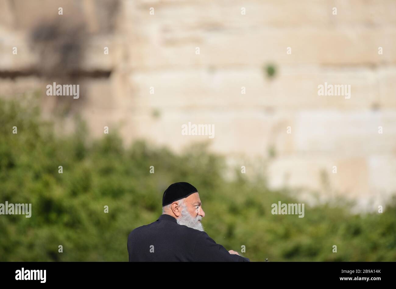 Ein religiöser jüdischer Mann, der auf den Tempelberg und den Ölberg aus der Altstadt von Jerusalem blickt. Stockfoto